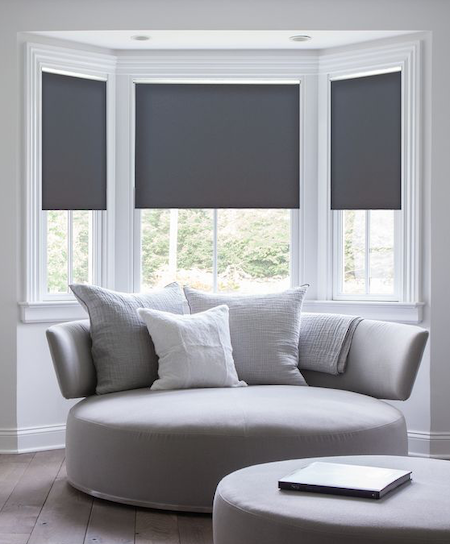 three blockout blinds in a bay window in a lounge setting