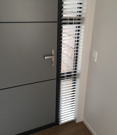 narrow pvc blinds next to the front door of a home entrance