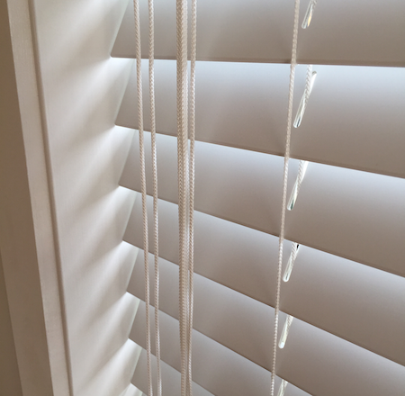 closeup of pvc blinds and the control cords