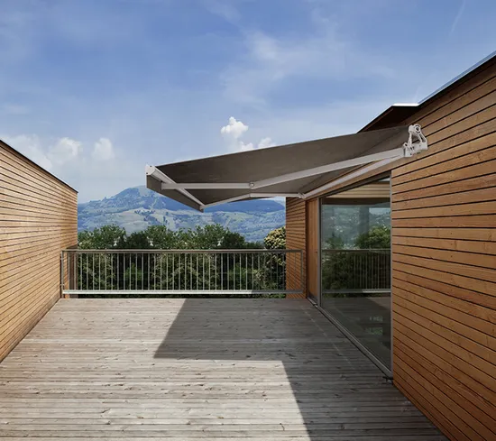 Retractable awning providing shade over elevated timber deck with mountain views