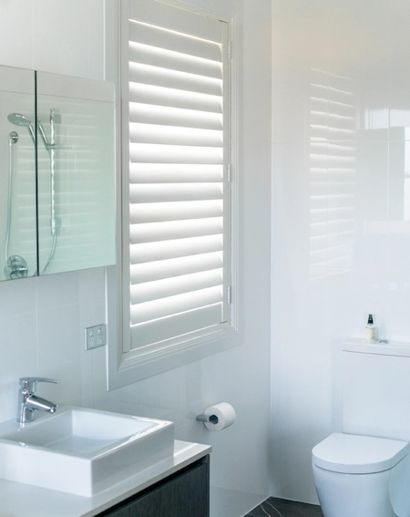 Plantation shutters in a bathroom for privacy, ventilation, and easy cleaning