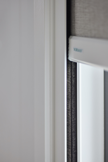Close-up of SmartBlock blackout blind side channel and bottom rail showing precise light-sealing design